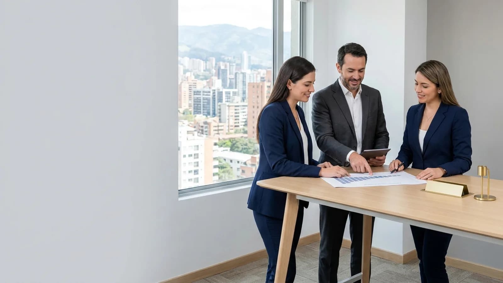 Tres consultoras y un consultor de gestión revisando un informe impreso y una tablet en una oficina de Quito